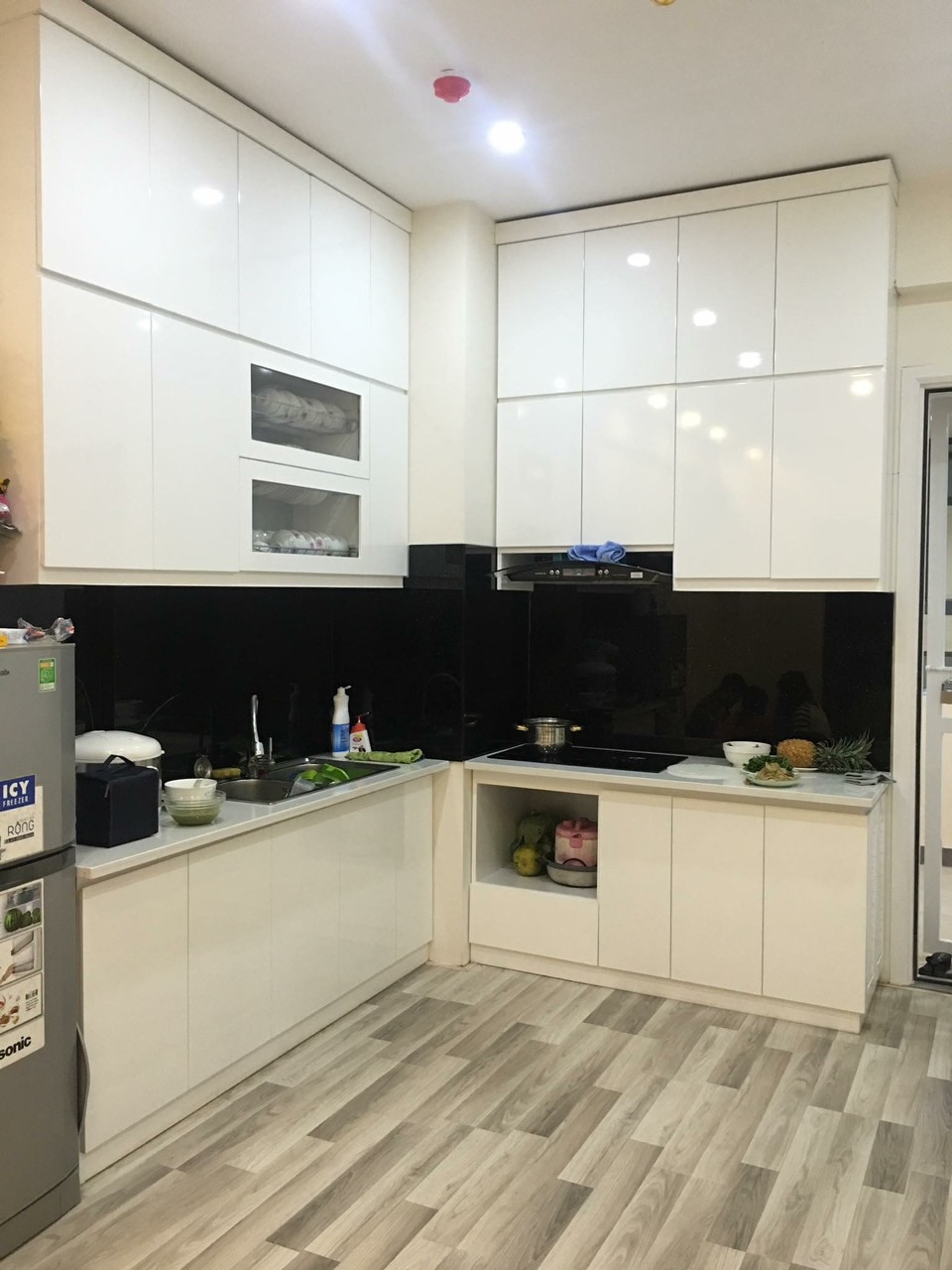 Bếp chữ L trắng kịch trần phối kính ốp bếp màu đen huyền bí - Bếp chữ L tại Khu vực Quảng Ninh