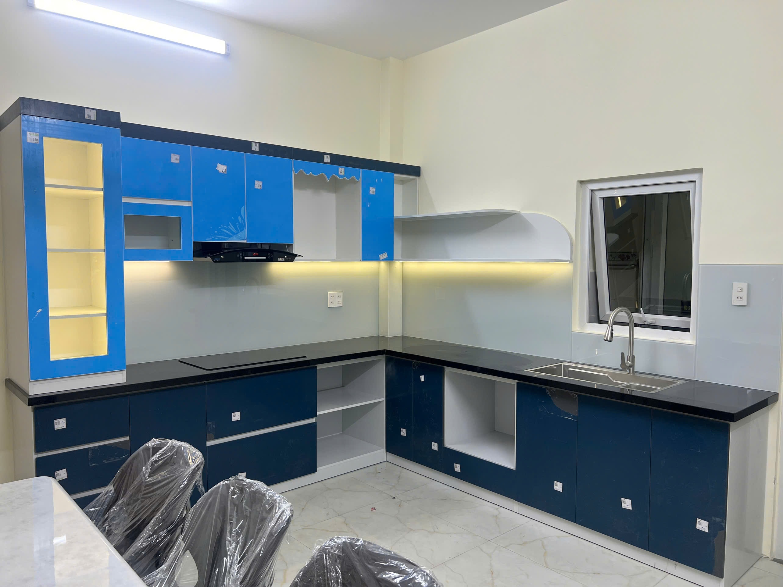 Tủ bếp thùng MDF cánh acrylic màu xanh lam phối trắng - Bếp chữ L tại Khu vực Hải Dương, góc nhìn 2