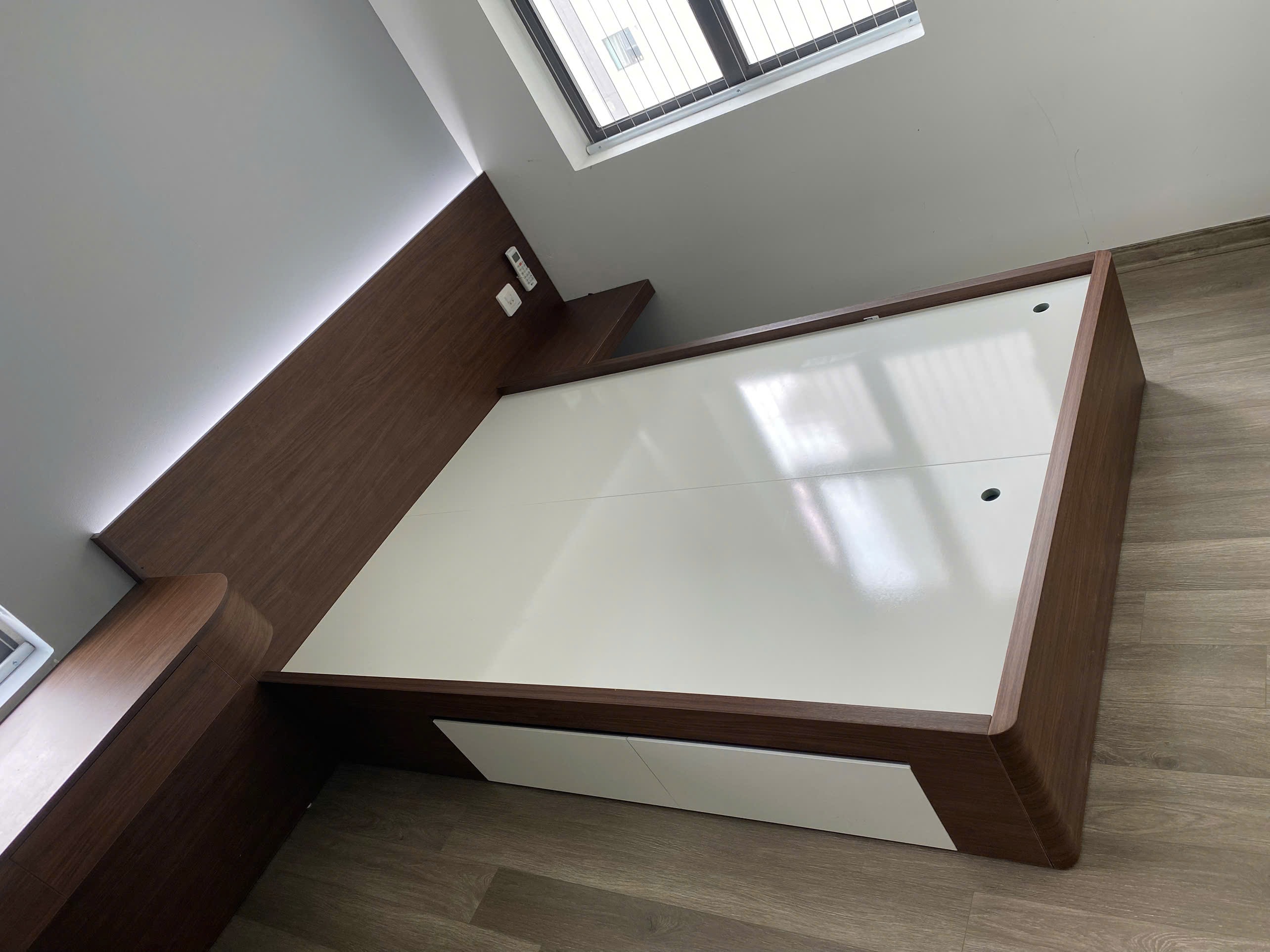 Phòng ngủ master gỗ MDF màu nâu trầm với các góc tủ và bàn trang điểm bo cong tinh xảo
