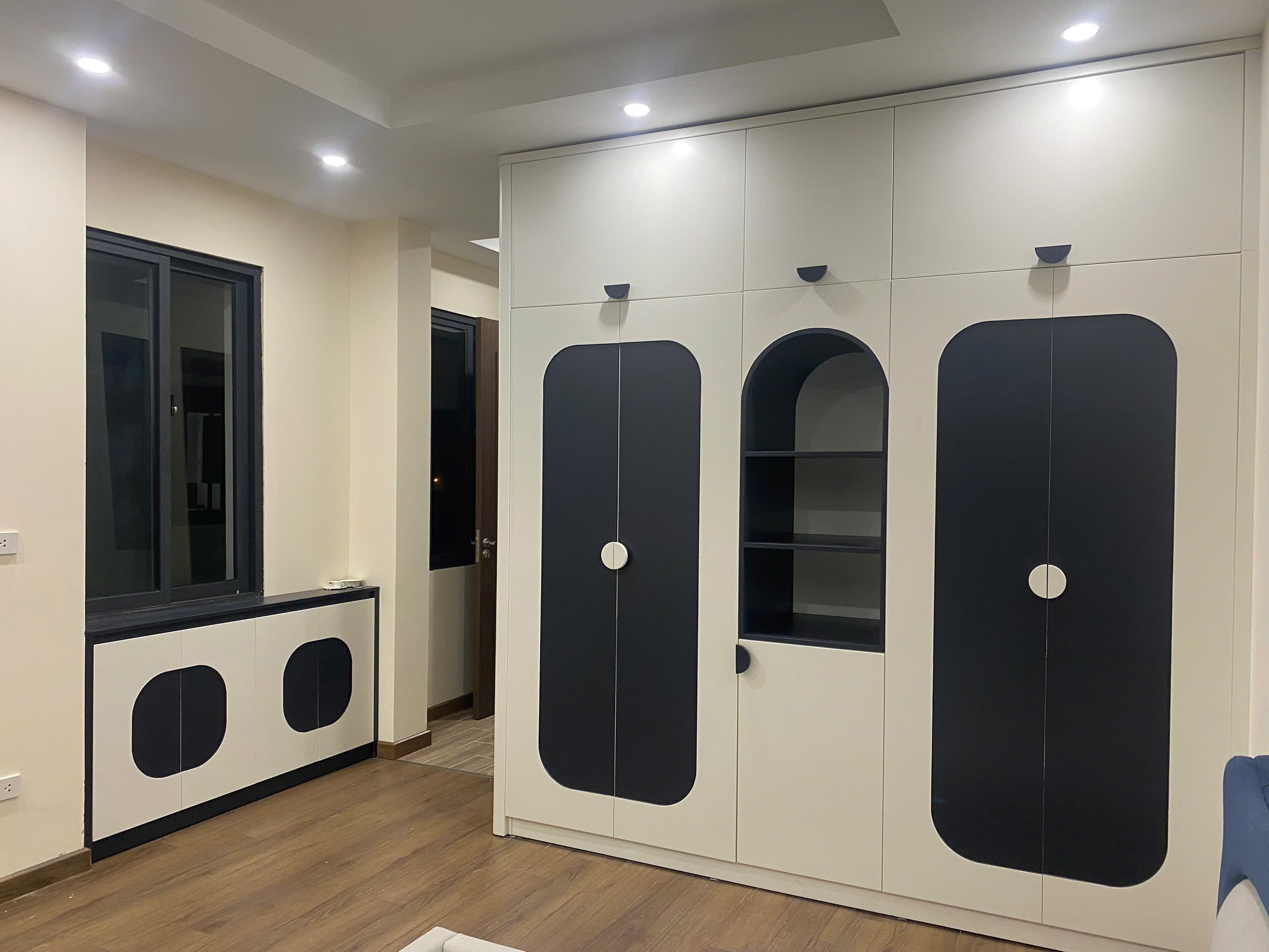 Phòng ngủ trẻ em gỗ MDF màu xanh navy với kệ vòm cong trưng bày đồ chơi sinh động