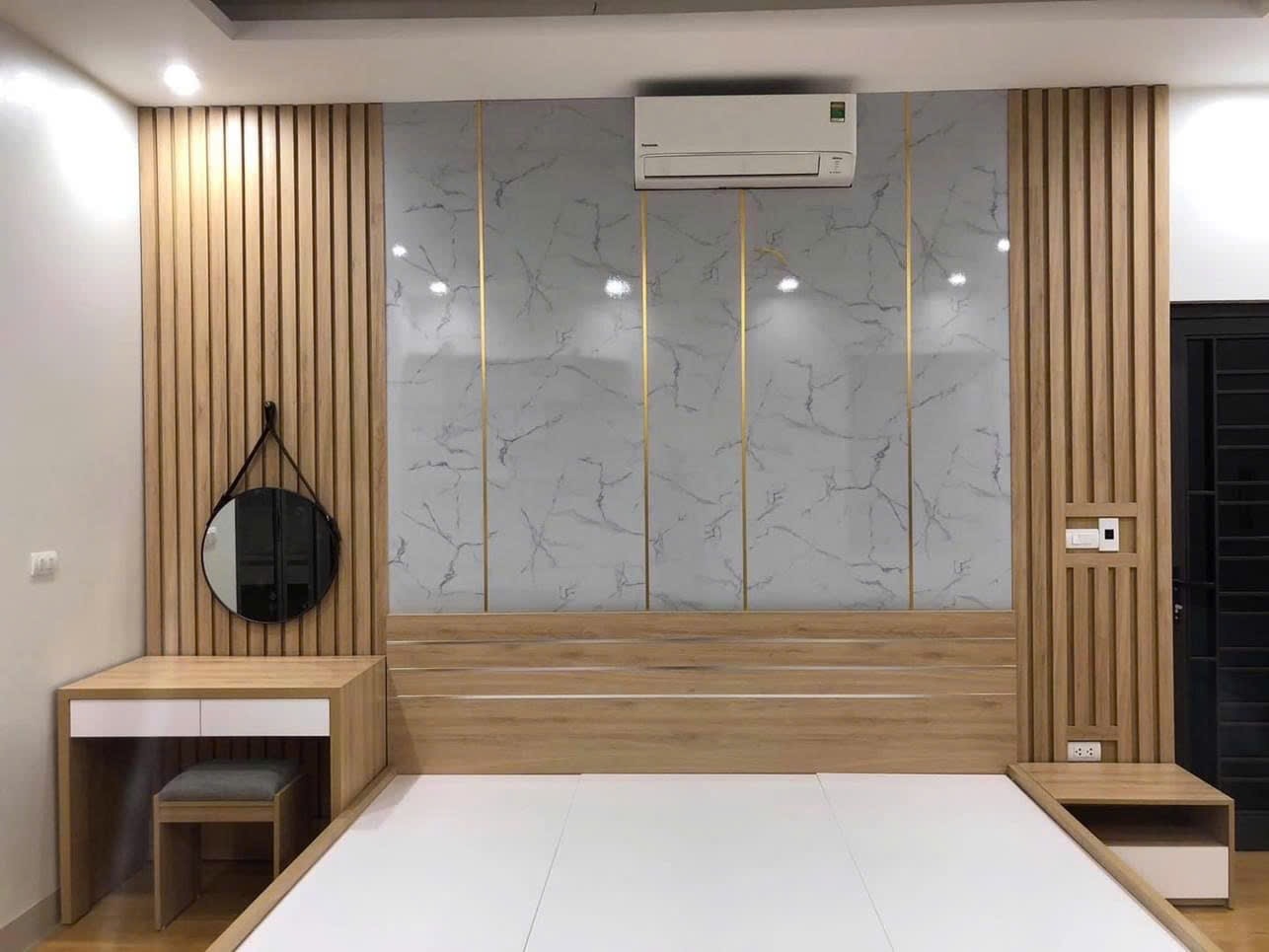 Vách ốp đầu giường đa chất liệu tấm vân đá, nan gỗ MDF và đường nẹp chỉ T mạ vàng