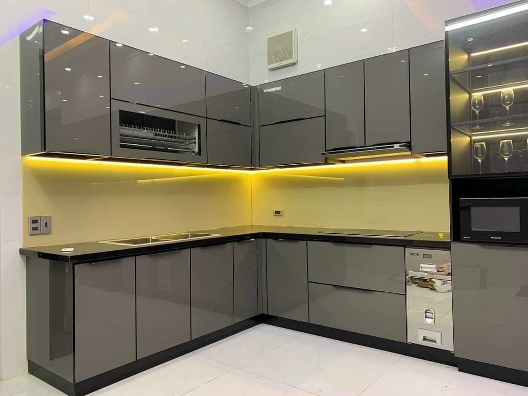 Tủ bếp Inox 304 cánh kính xám khói với ánh đèn vàng, góc nhìn 1